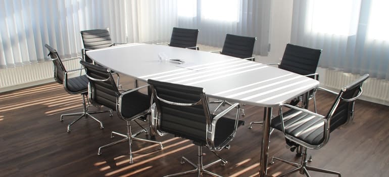 There is a big table and a lot of chairs in the meeting room.