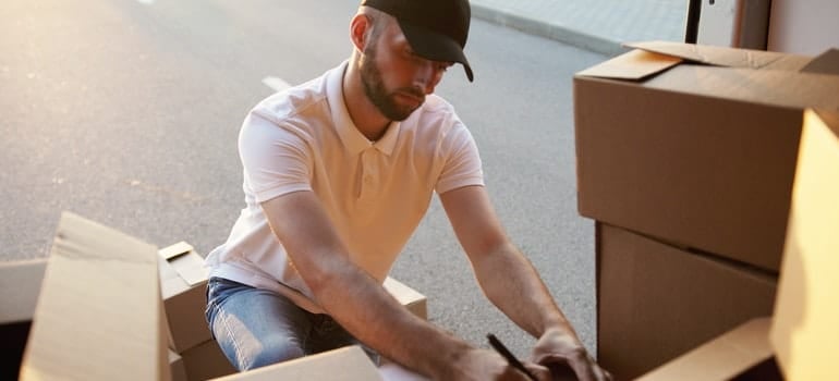 A professional mover writing down dimension of a piano