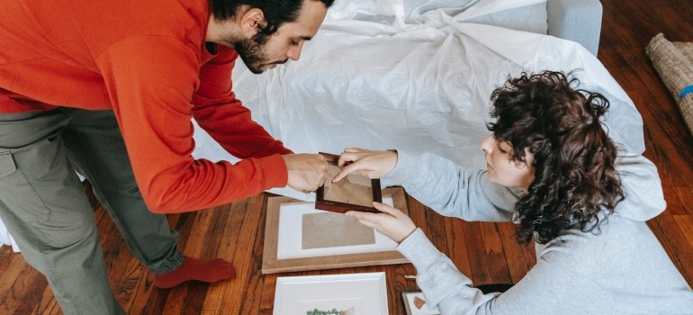 a couple preparing a framewor when moving art pieces from Coral gables to Fort Lauderdale