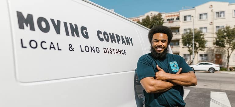 a man standing by moving company van