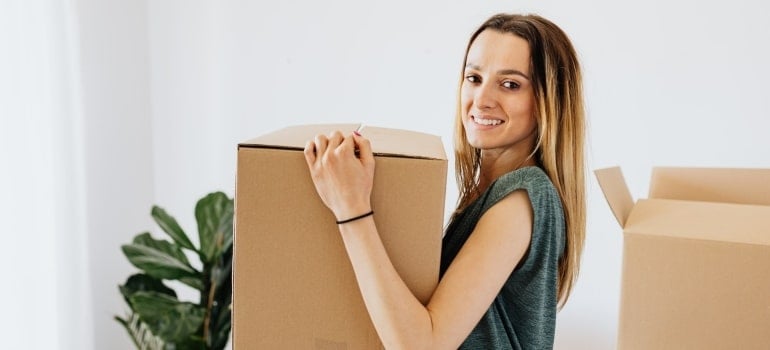 a woman carrying a cardboard box