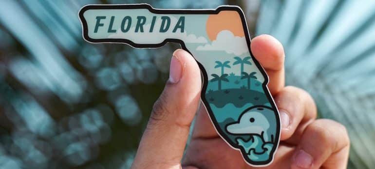 A man holding a Florida magnet