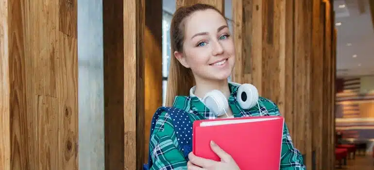 A girl Standing in Hallway While Holding Book