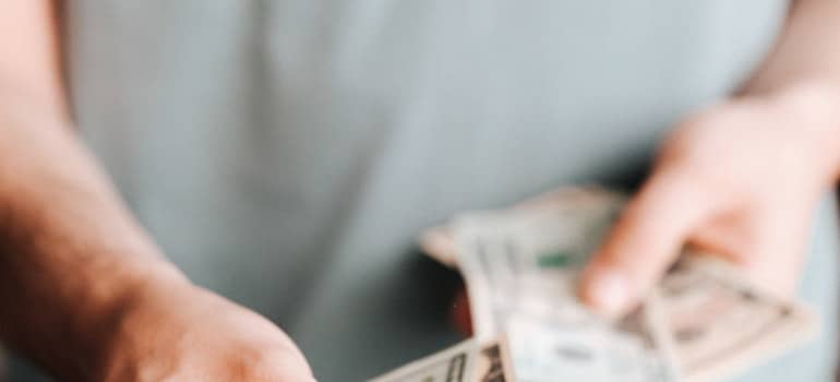 A person in a gray shirt holding money