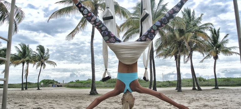 A woman is doing yoga on the beach.