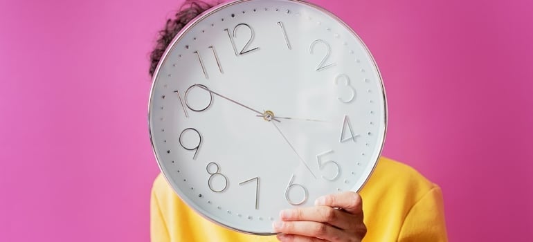 Person holding a clock