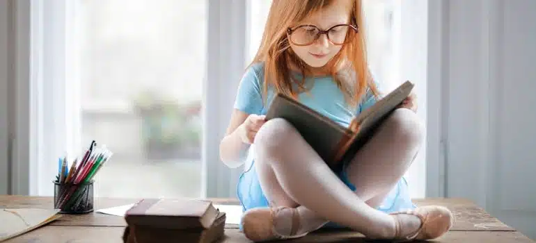 A Girl Reading a Book on a desk