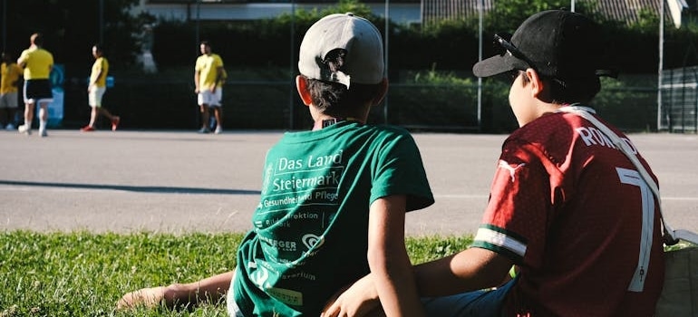 Two Boys Watching a Local Soccer Game Outdoors in one of the best school districts in Miami