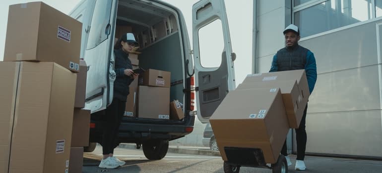 Two movers loading moving boxes