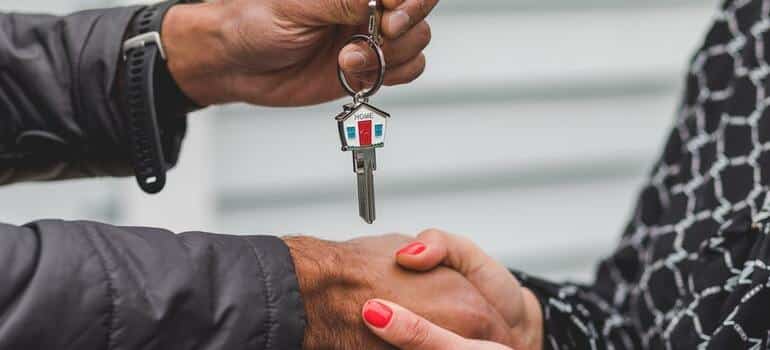 A person giving the keys to a home to another person