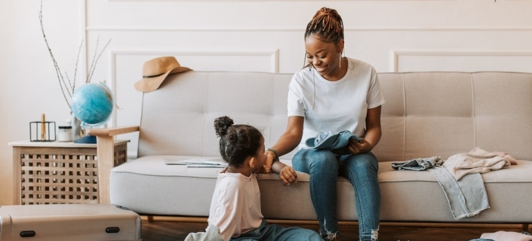 a mother and daughter packing and laughing before their family relocation to Aventura