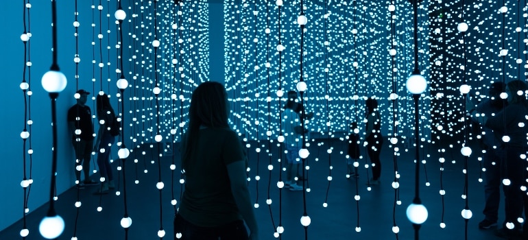 Silhouette of a woman standing in front of blue lights photo.