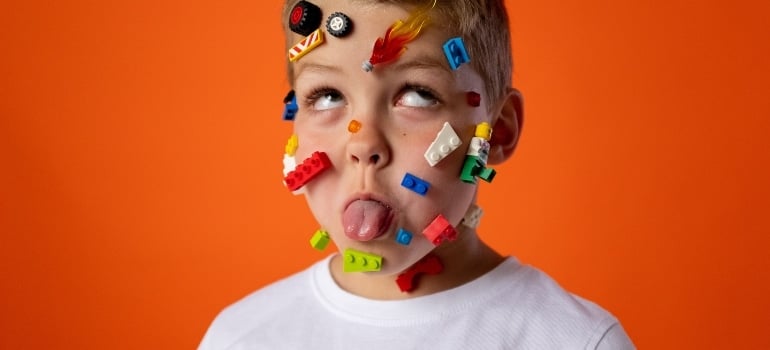 kid with lego cubes on face