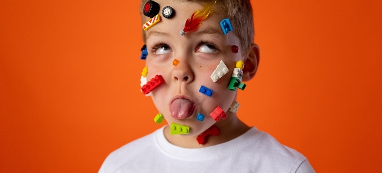 kid with lego cubes on face