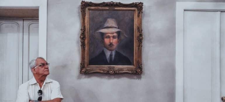 A man standing next to a framed picture