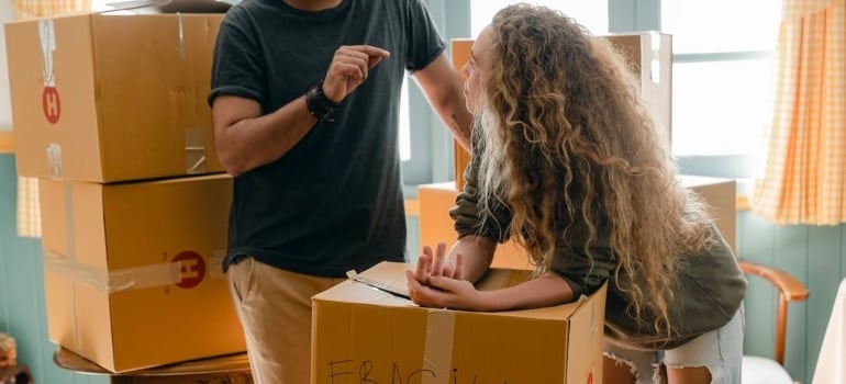 a couple talking while packing boxes 