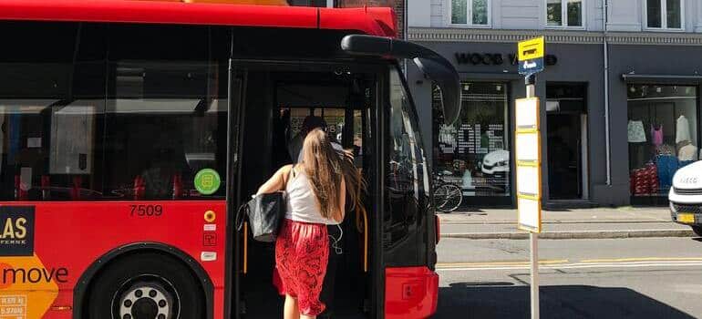 a girl in red skirt going into a bus