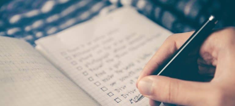 Someone writing a detailed checklist for packing for a last-minute move to Brickell.