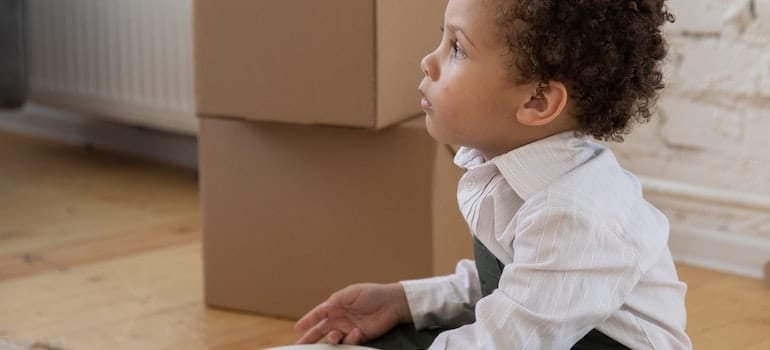 A boy next to the moving boxes