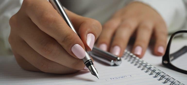 A woman writing a moving list