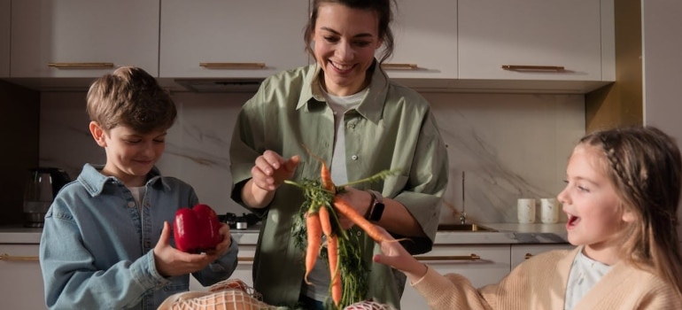 a mother and her children unpacking vegetables