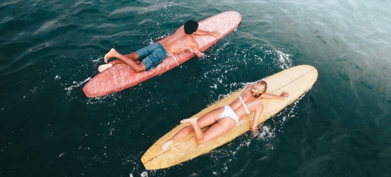 a man and a woman on a surf board