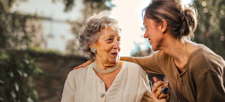 Young woman hugging old woman;