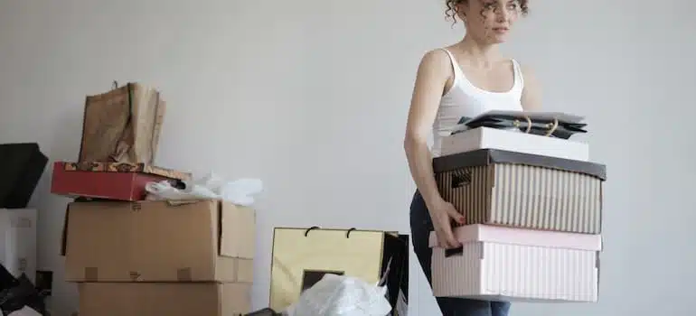 A woman carrying boxes and thinking about how to emotionally prepare for leaving Florida;