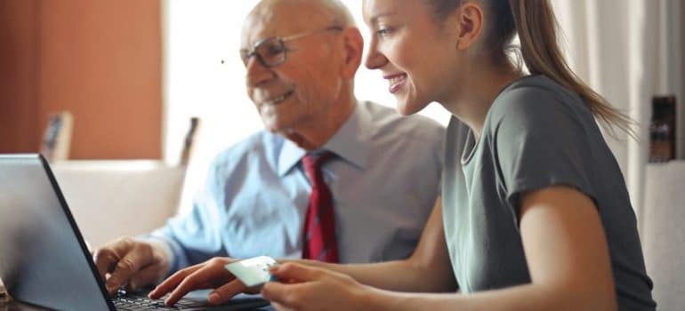 A grandfather and granddaughter typing