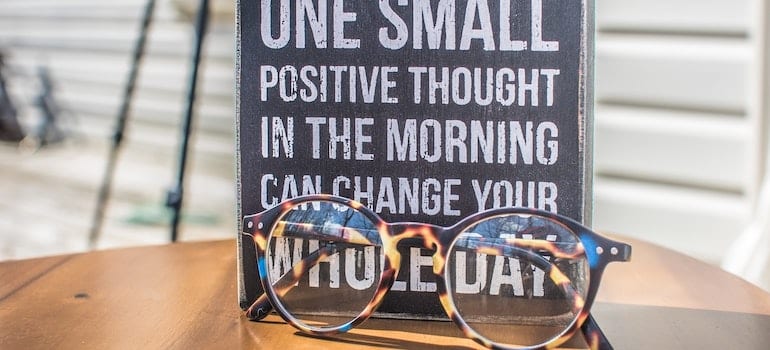 A photo of a sign and eyeglasses on table;