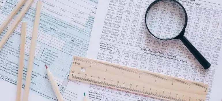 papers, pencils, a ruler and a magnifying glass