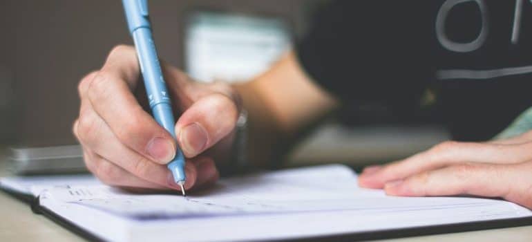 A person writing a list for the best Miami neighborhoods for families with kids