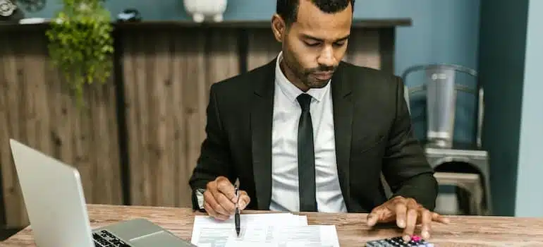 Man in black suit calculating living costs;