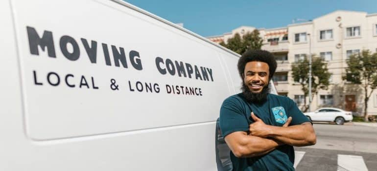 A mover stynding next to a moving truck