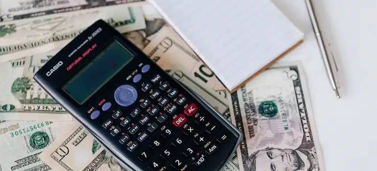 A calculator and a notepad next to insurance papers, something you'll need to think about after buying a new home in Miami Beach.