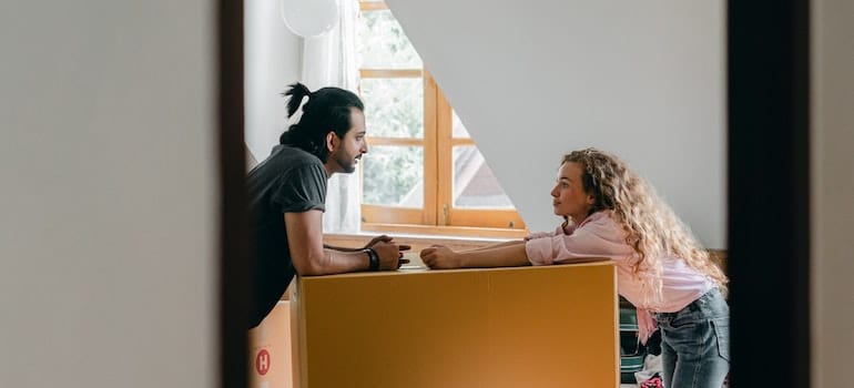 A man and a woman discussing how to arrange everything in their new home.