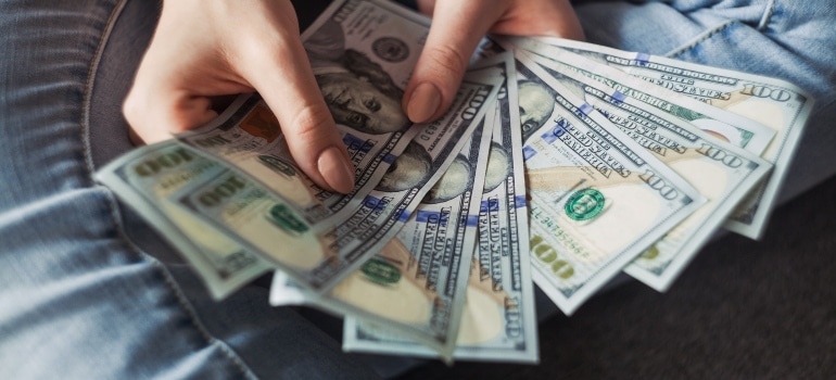 a woman counting dollars in order to prepare for moving to South Beach alone