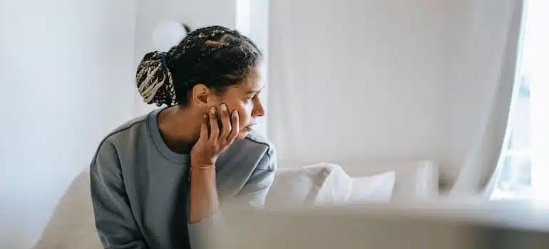 Lady sitting on bed in light room