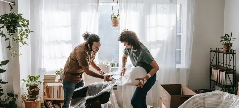 One friend helping to other to wrap the chair