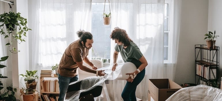 Couple putting bubble wrap on a chair