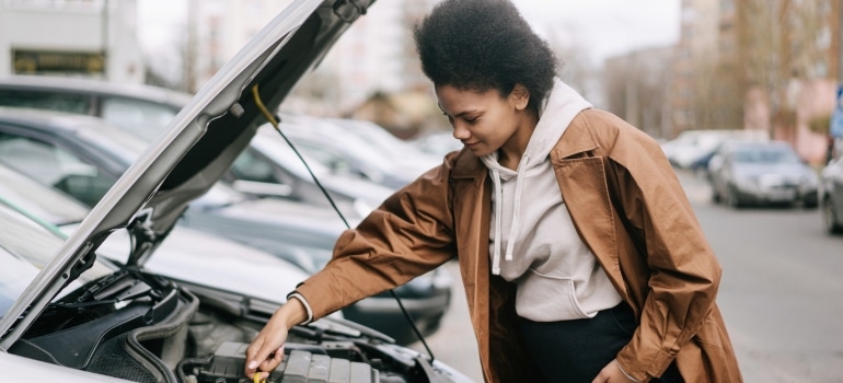 Picture of a woman fixing a car 