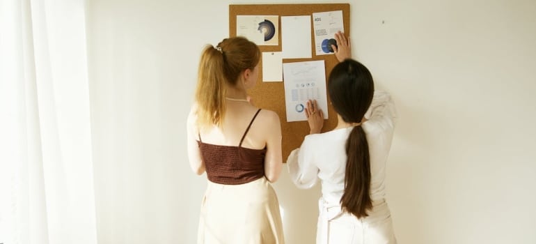 two women comparing graphs on the board