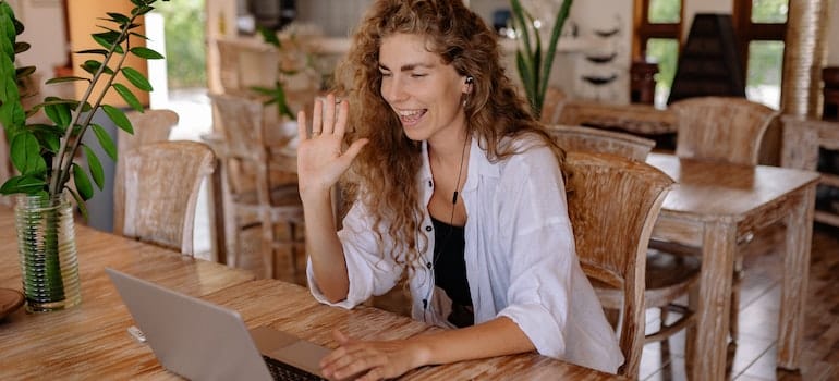 Woman in white shirt sitting on chair in front of Macbook