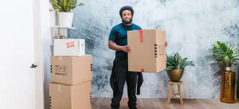 A mover holding a cardboard box