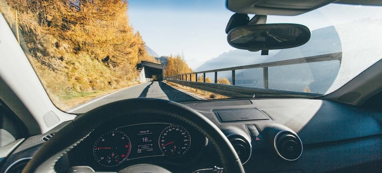 A person driving a car with the view up ahead.