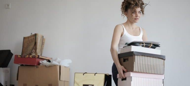 a woman carrying boxes before moving to Doral alone
