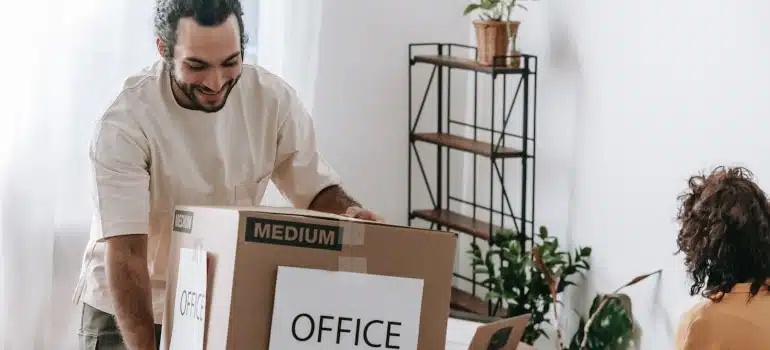 A man carrying a box labeled office