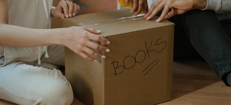 Picture of a couple unpacking a labeled box 