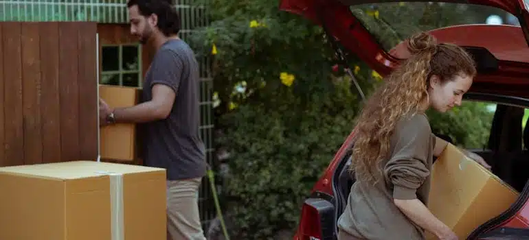 A couple loading a car with boxes before an interstate relocation