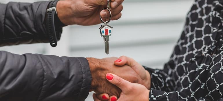 Man handing over a key and shaking hands